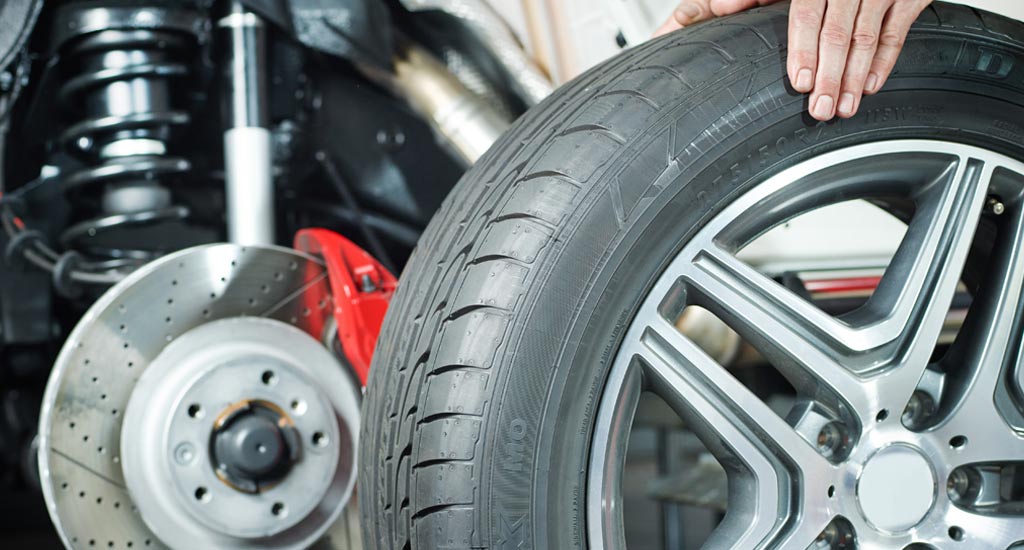 Car mechanic is changing a tyre in a garage